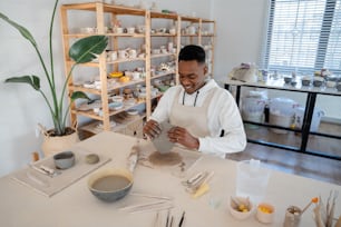 Un hombre en un estudio de arte trabajando en una pieza de cerámica