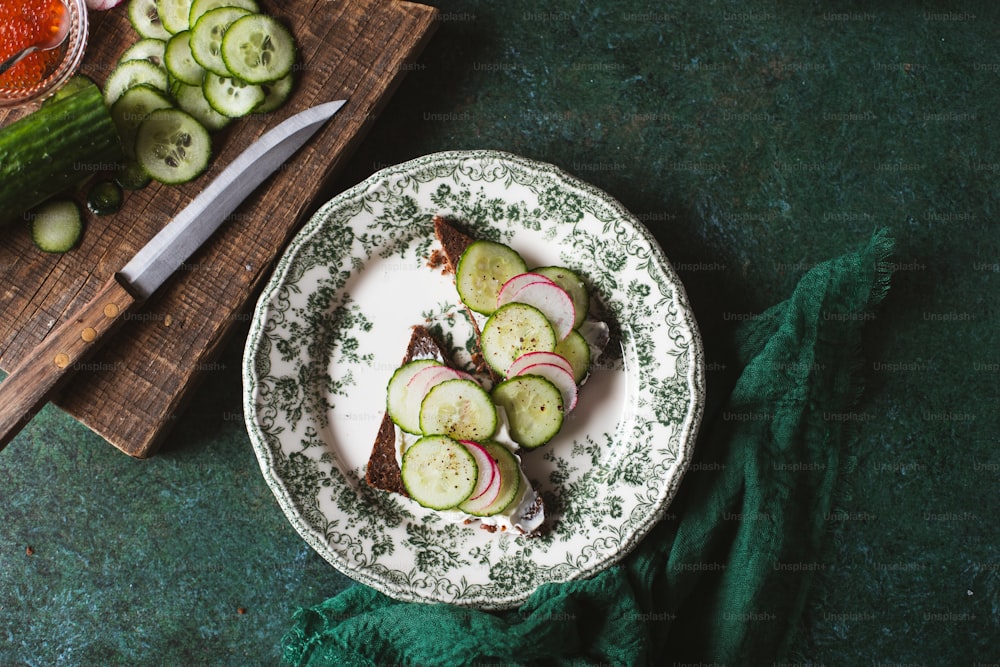a plate of sliced cucumbers and a knife on a cutting board