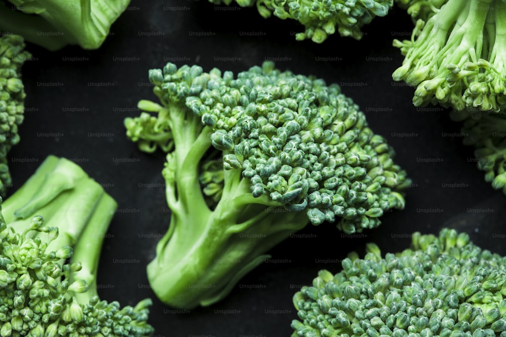 Un primo piano di cimette di broccoli su una superficie nera