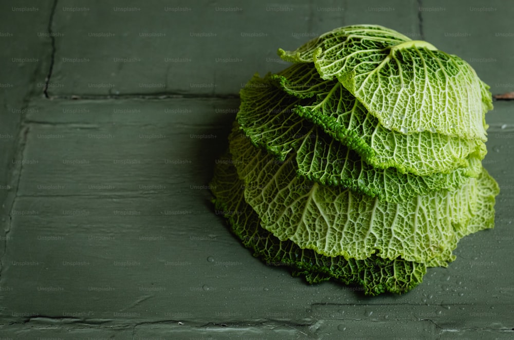 a pile of green cabbage sitting on top of a floor