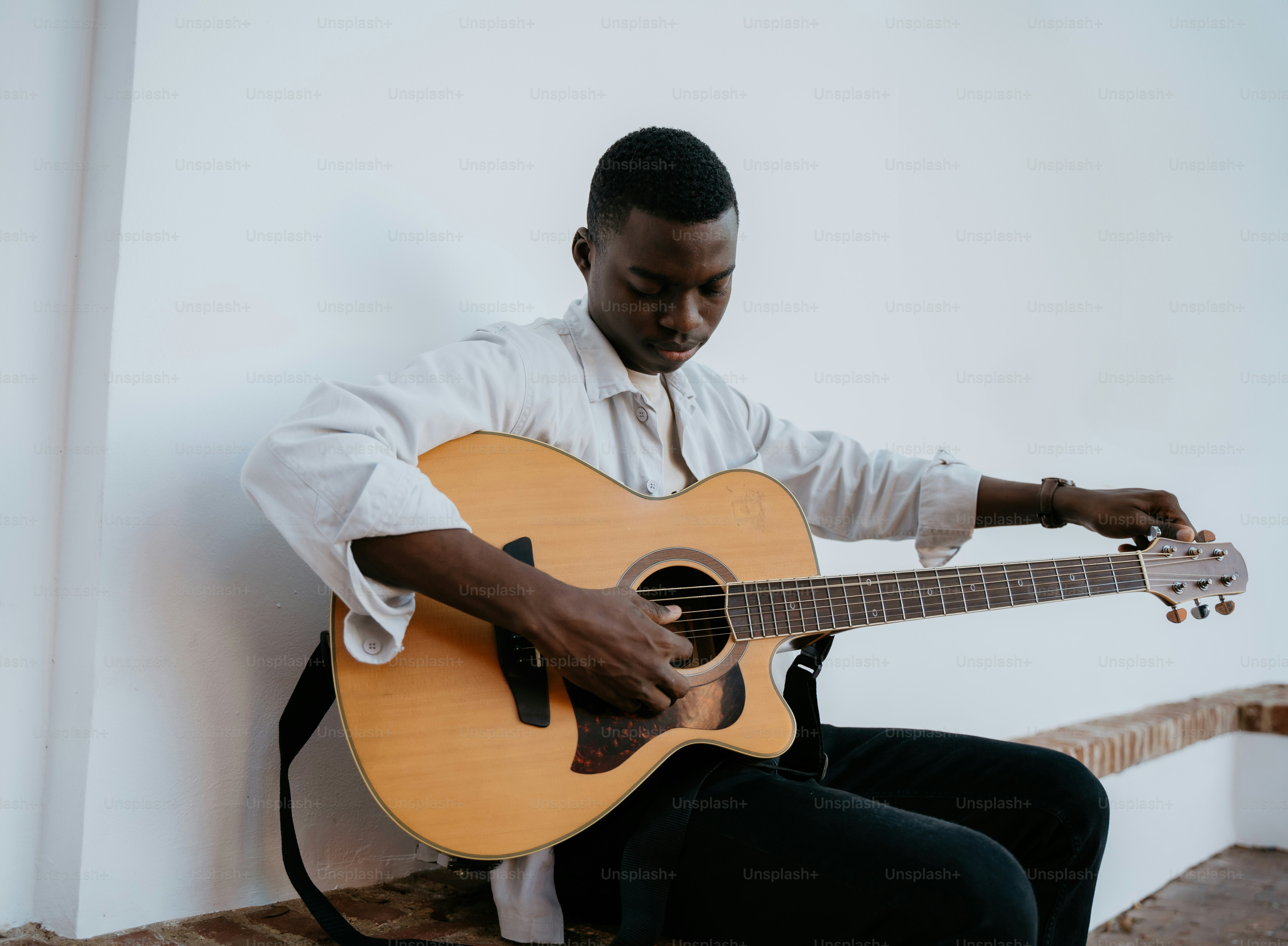 a man sitting on a bench playing a guitar