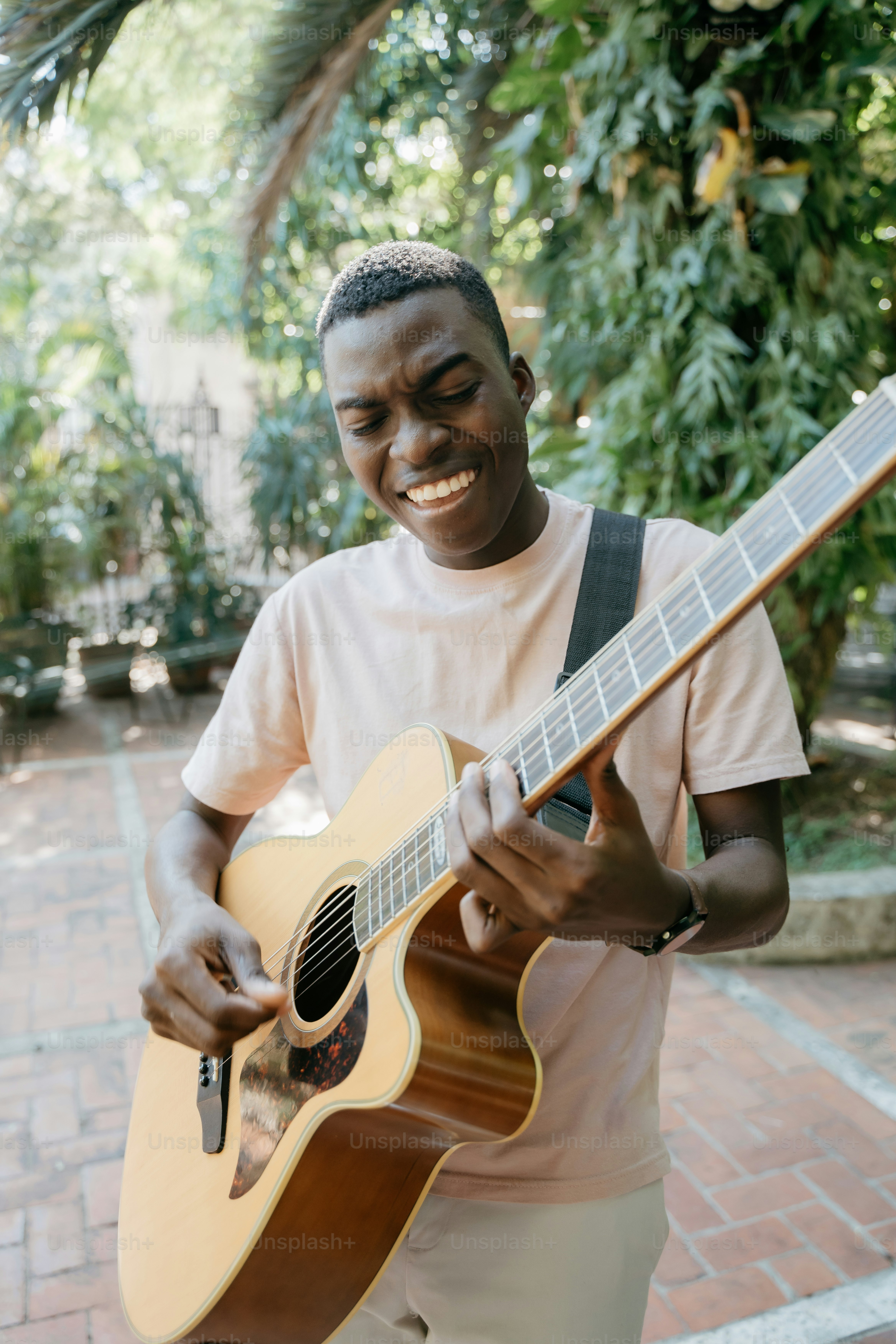 a man holding a guitar and smiling at the camera