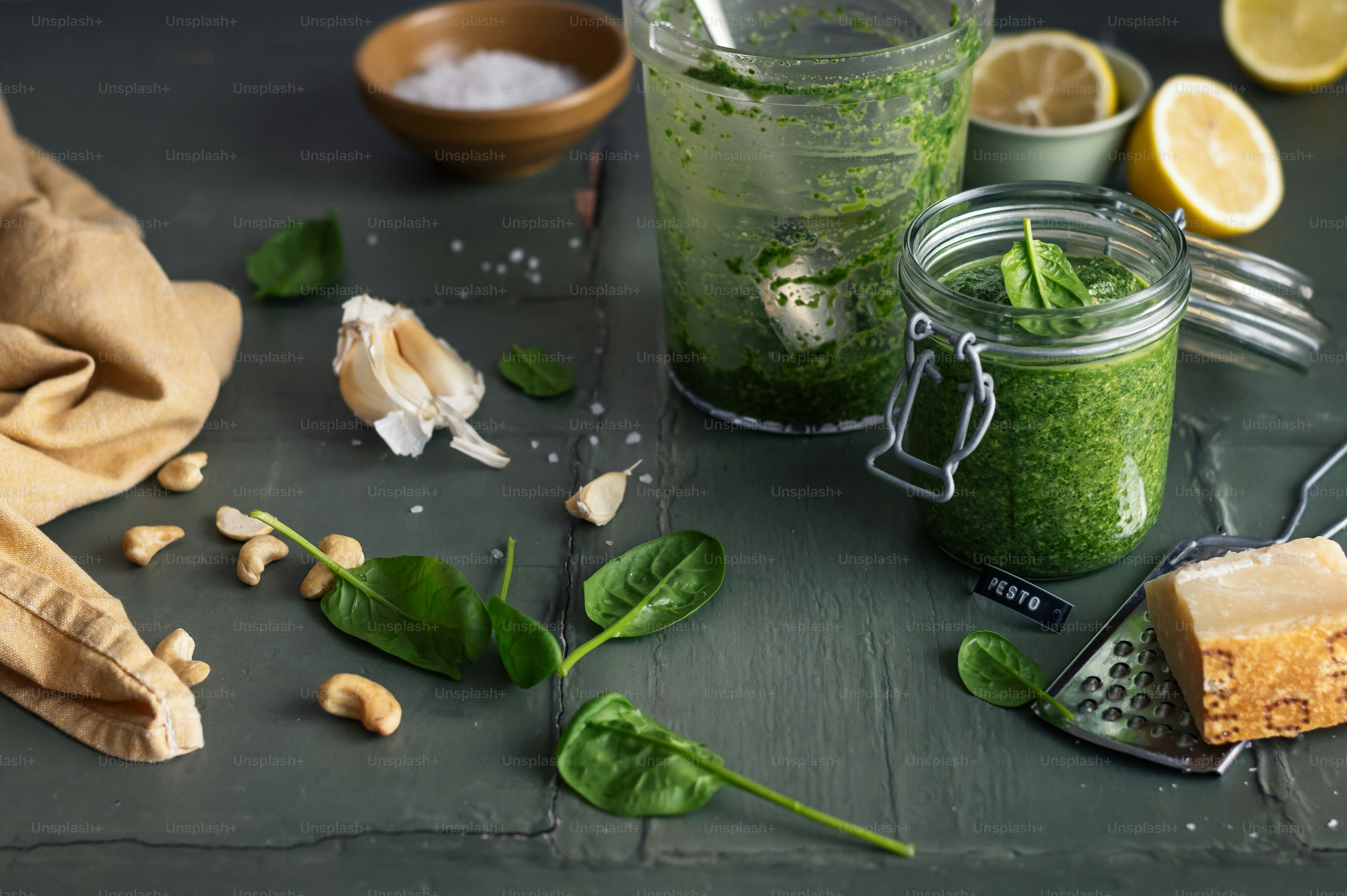 a jar filled with green stuff next to a couple of lemons