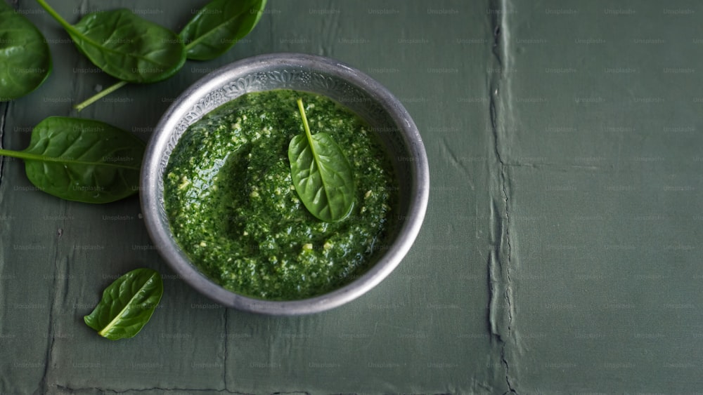 a bowl of pesto on a table