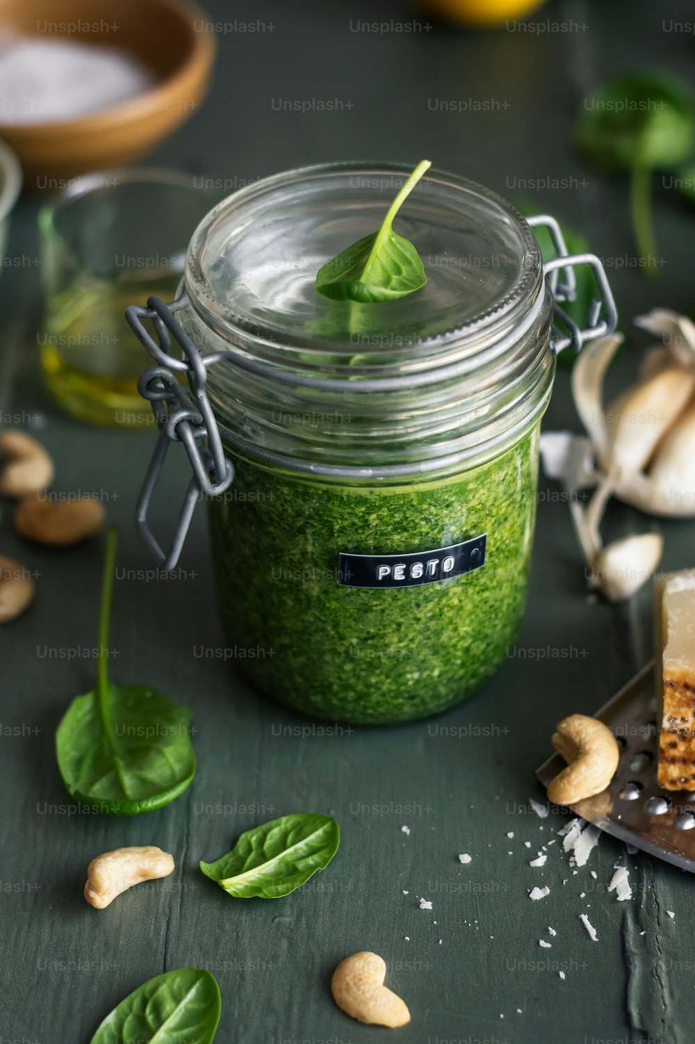 a jar filled with green food next to a slice of cake
