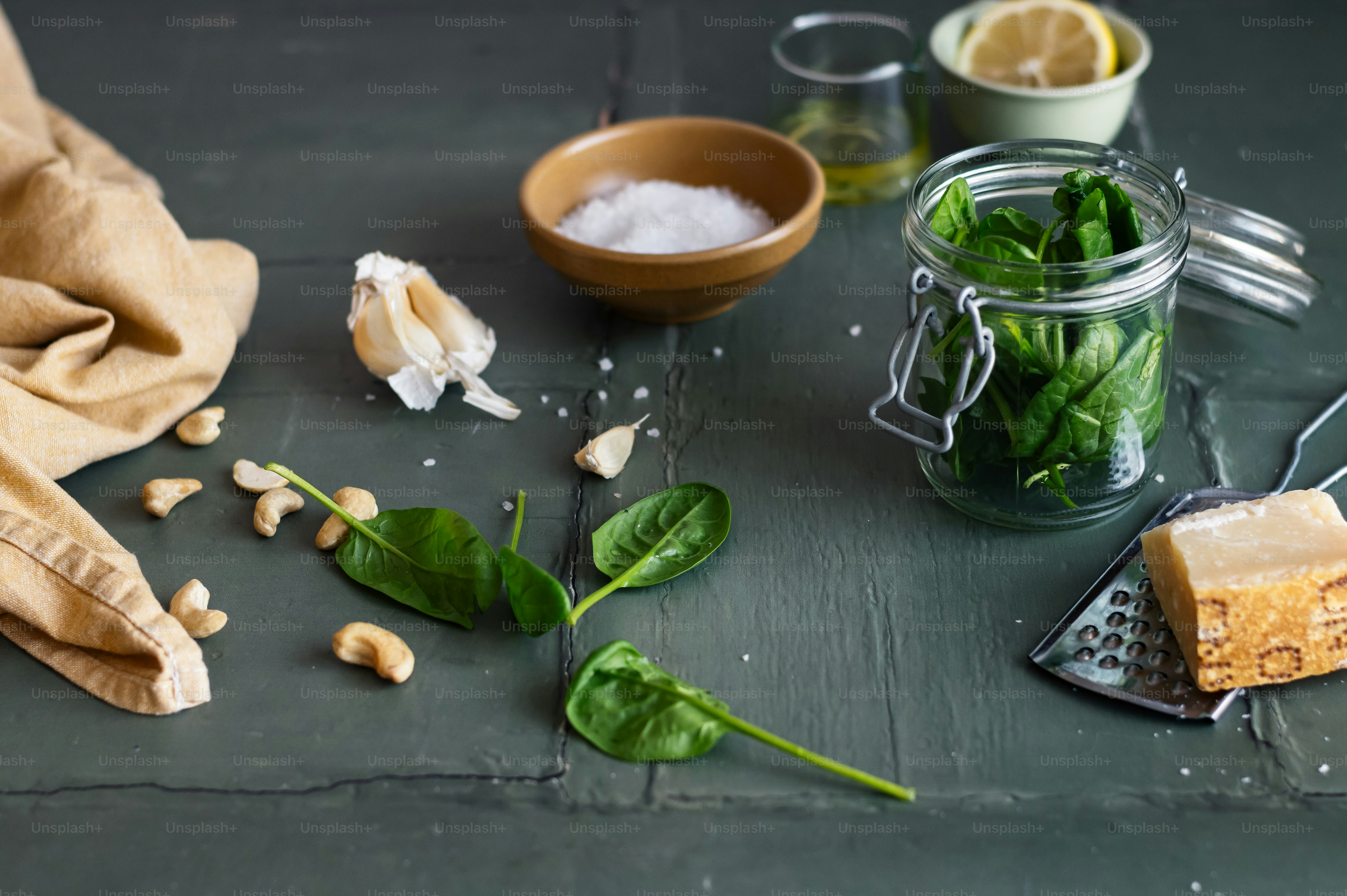 a table topped with a jar filled with green leaves