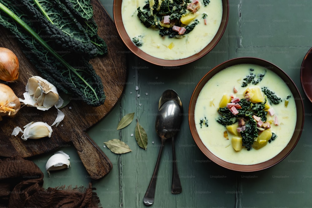 two bowls of soup with broccoli and other vegetables