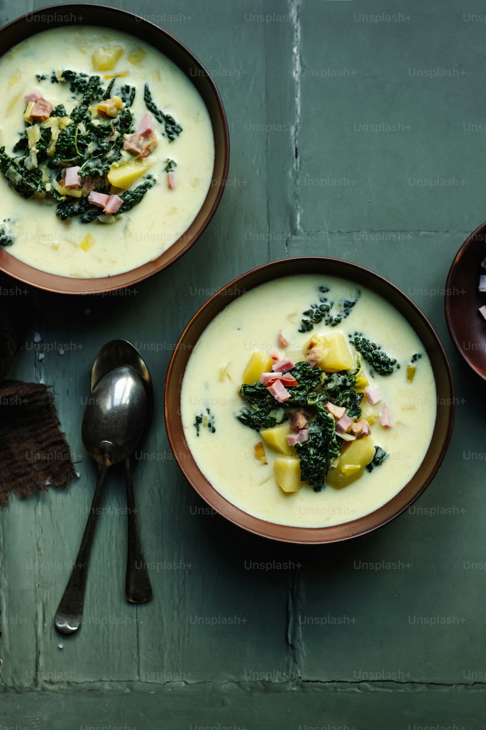 two bowls of soup with broccoli and ham