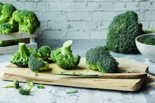 a cutting board topped with broccoli on top of a table