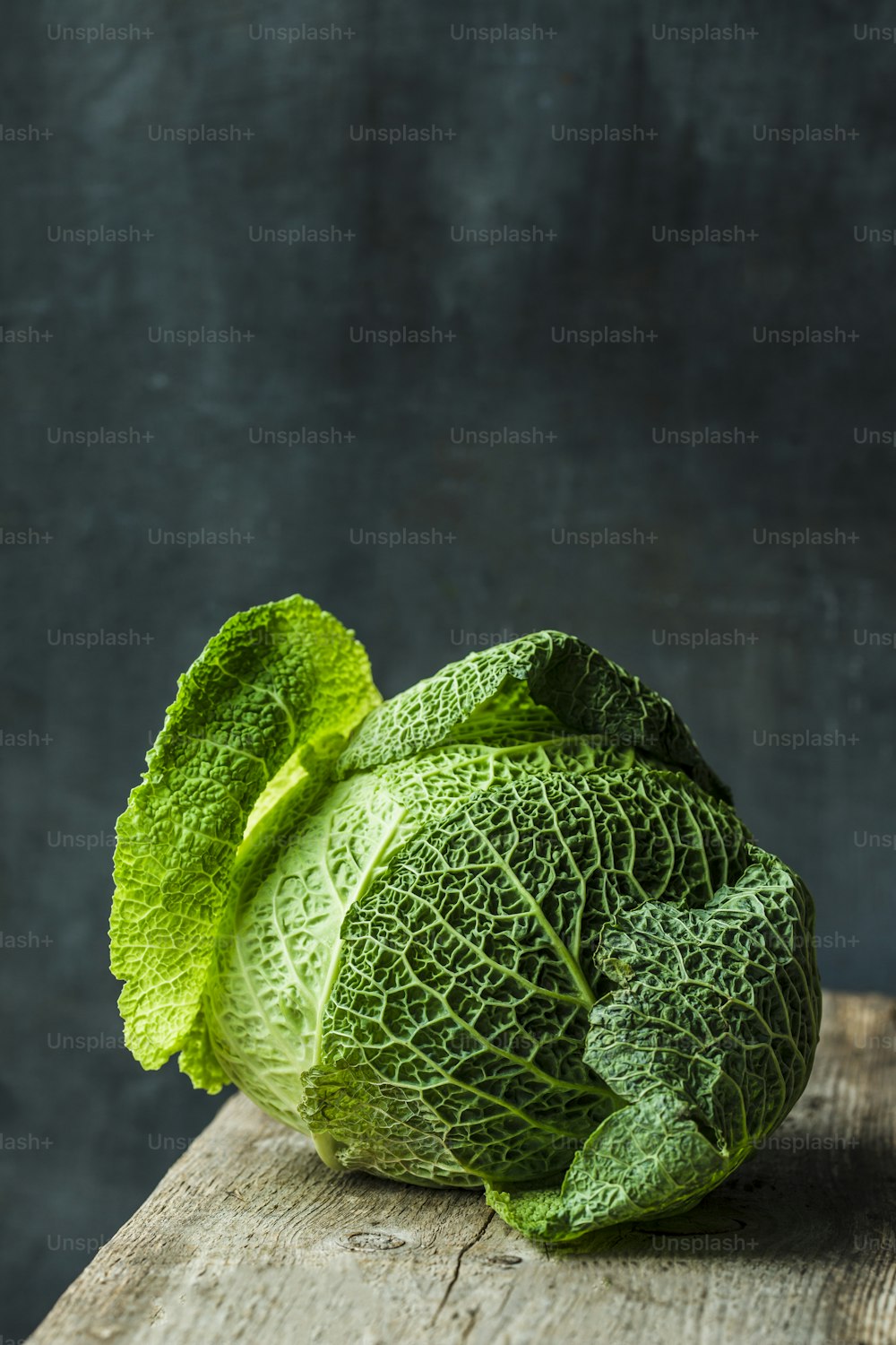 a head of cabbage sitting on top of a wooden table