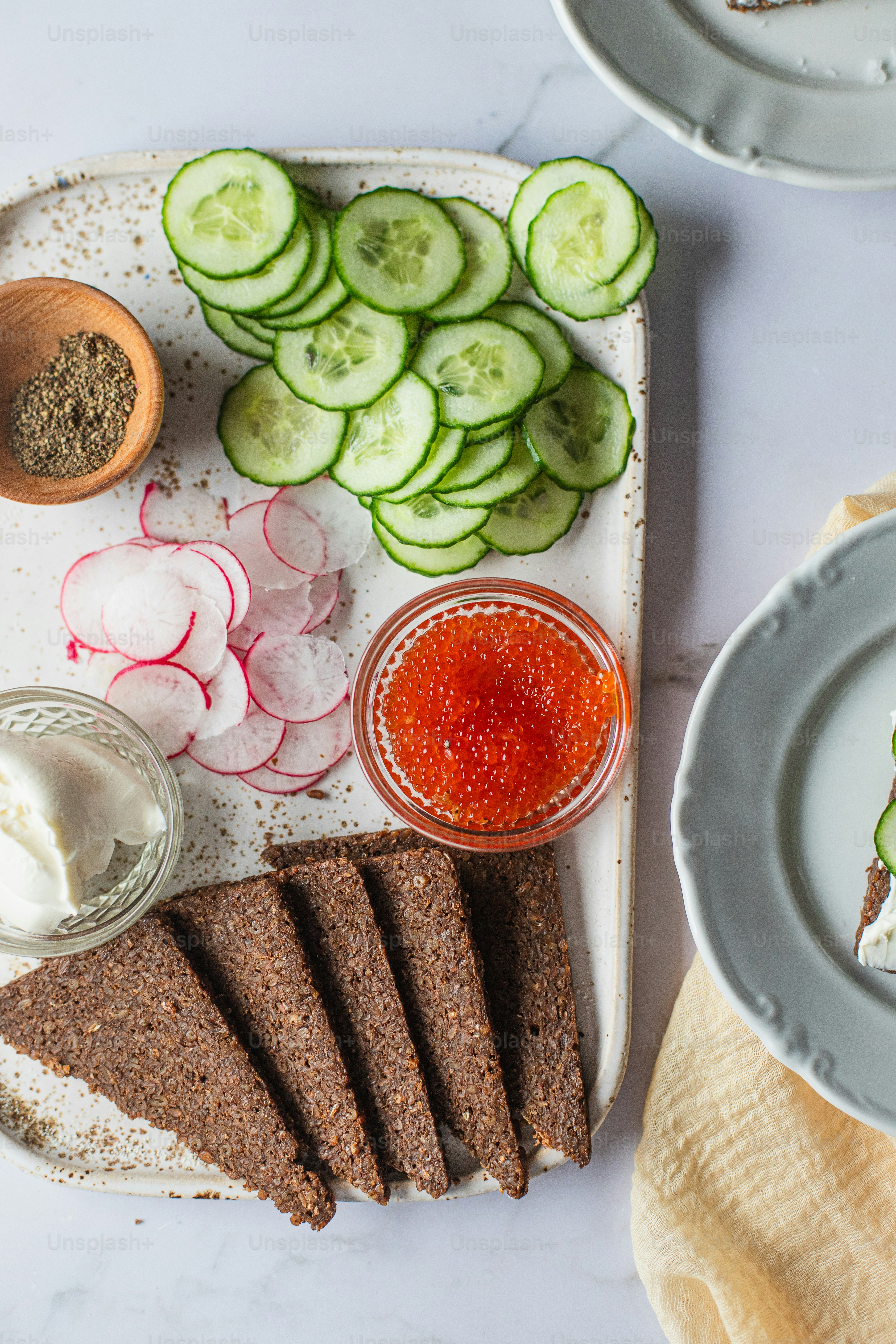 A plate of food with cucumbers, bread, and sauce photo – Lunch Image on ...