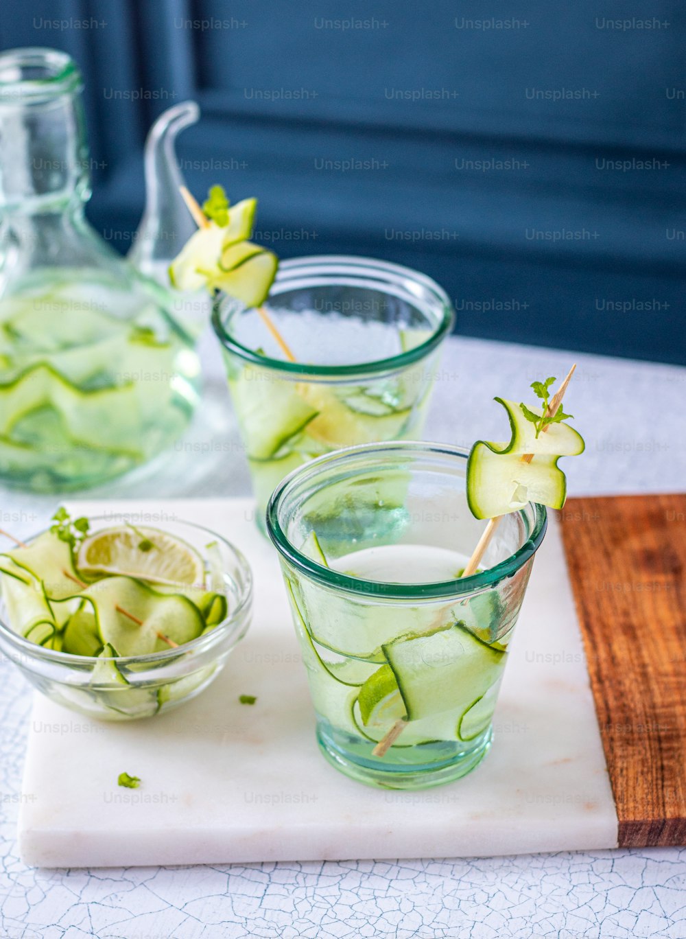 a table topped with glasses filled with cucumbers