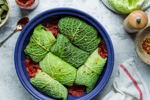 a blue bowl filled with green leafy vegetables