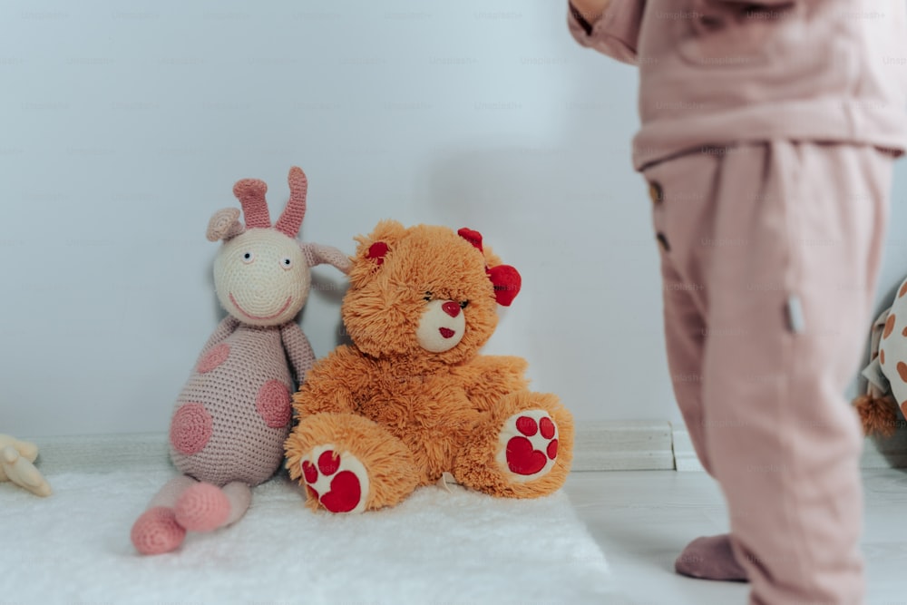 a person standing next to a group of stuffed animals