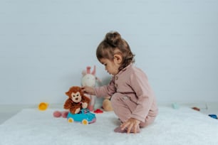 a little girl playing with a stuffed animal