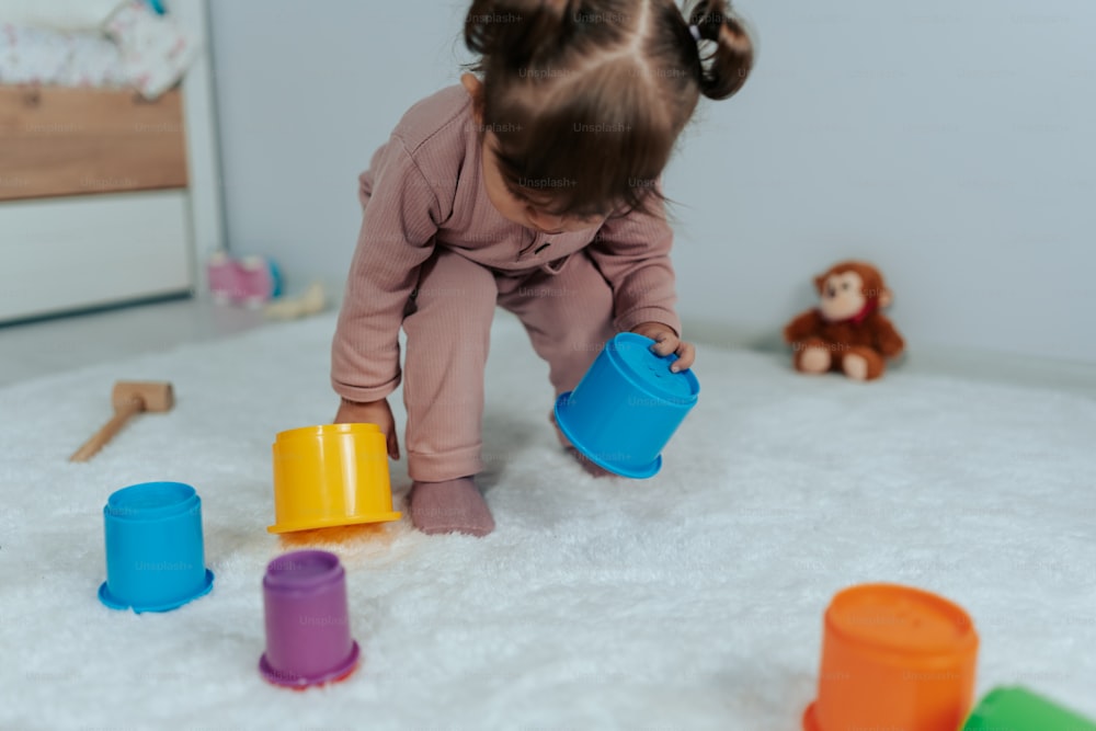 una niña jugando con juguetes en el suelo