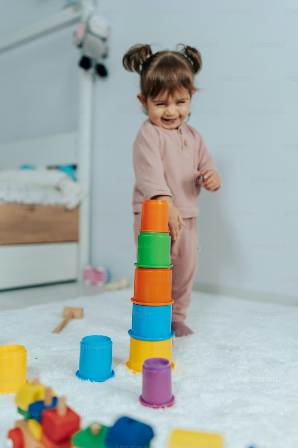 a little girl playing with a stack of blocks
