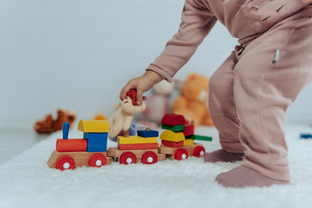 uma criança pequena brincando com um trem de brinquedo