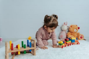 a little girl playing with toys on the floor