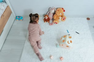 a little girl sitting on the floor playing with toys