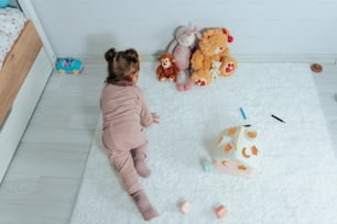ein kleines Mädchen sitzt auf dem Boden und spielt mit Spielzeug
