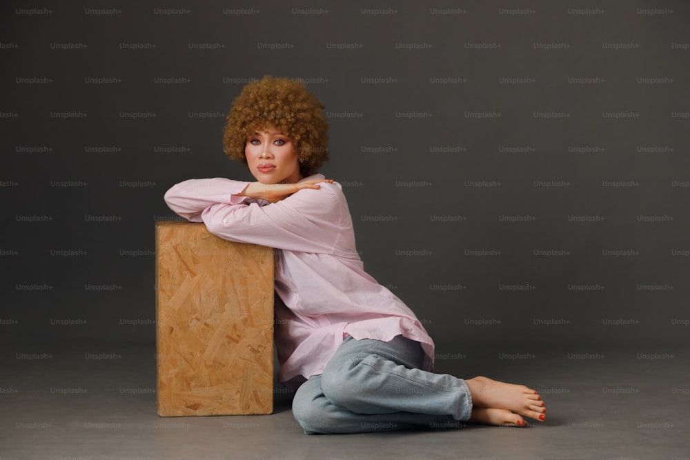 una mujer sentada en el suelo con los brazos cruzados