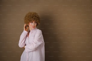a woman with curly hair is talking on a cell phone