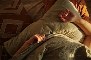 a person laying in a bed with a pillow