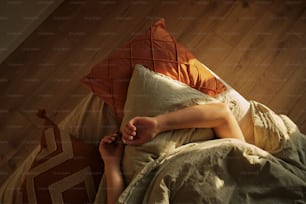 eine Frau, die mit den Füßen auf einem Kissen im Bett liegt