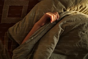 una persona avvolta in una coperta su un letto