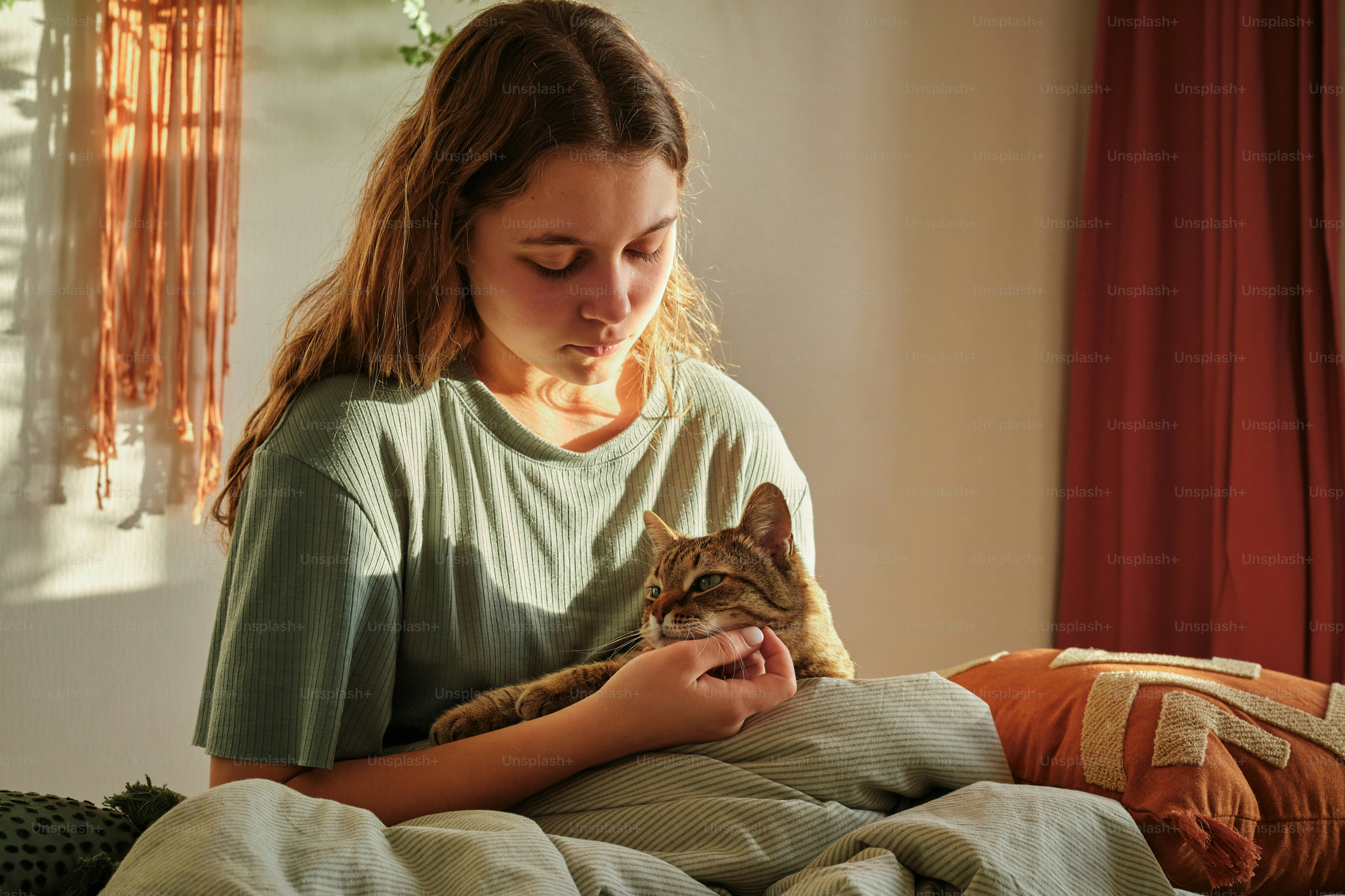 a woman holding a cat while sitting on a bed