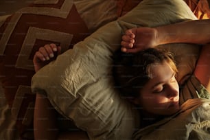 une femme allongée dans son lit, la tête sur un oreiller