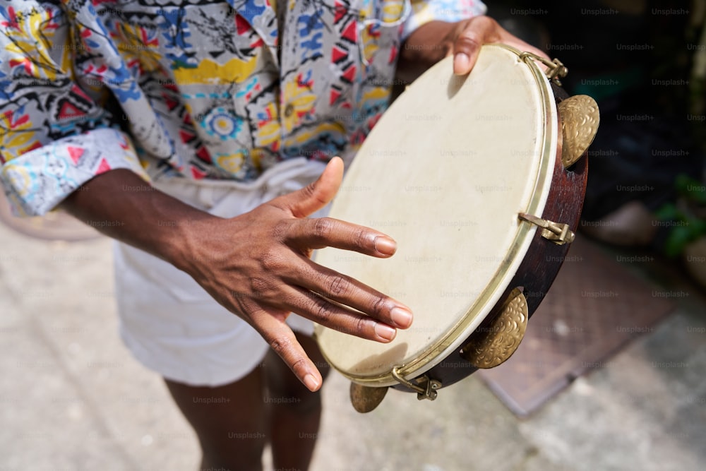 un homme tenant un grand tambour en bois dans ses mains
