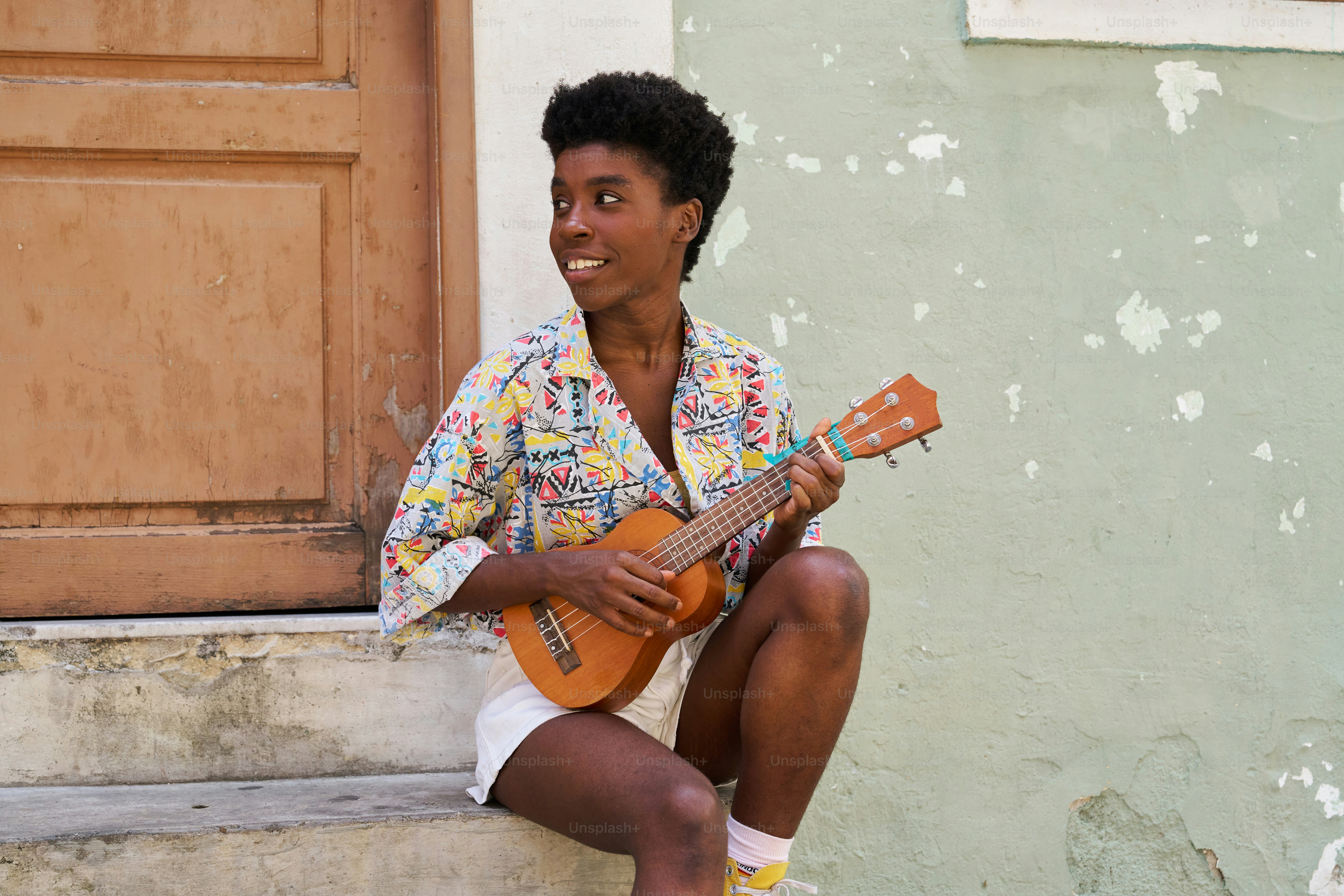 A man sitting on the steps playing a guitar photo – Music Image on Unsplash