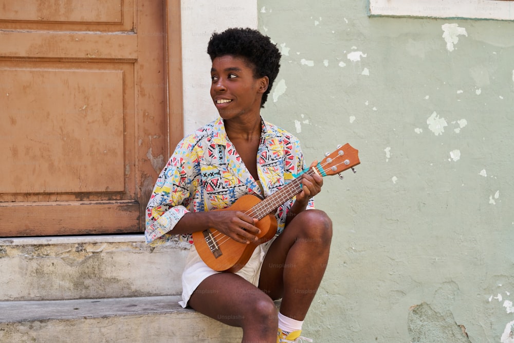 a woman sitting on the steps playing a guitar