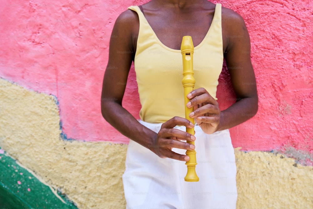 a woman in a yellow top holding a yellow flute