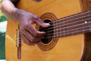 um close up de uma pessoa tocando guitarra