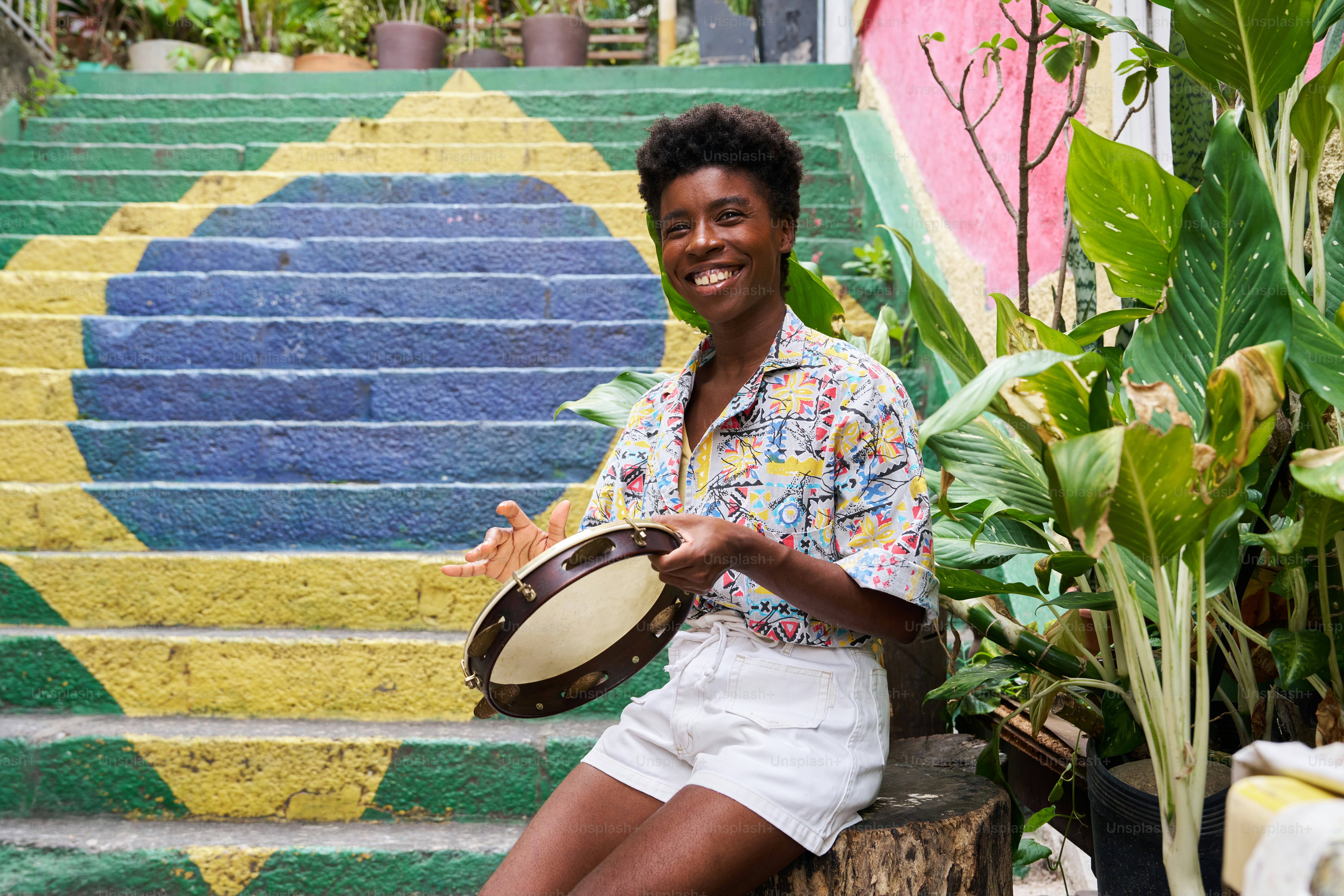 a woman sitting on steps holding a drum