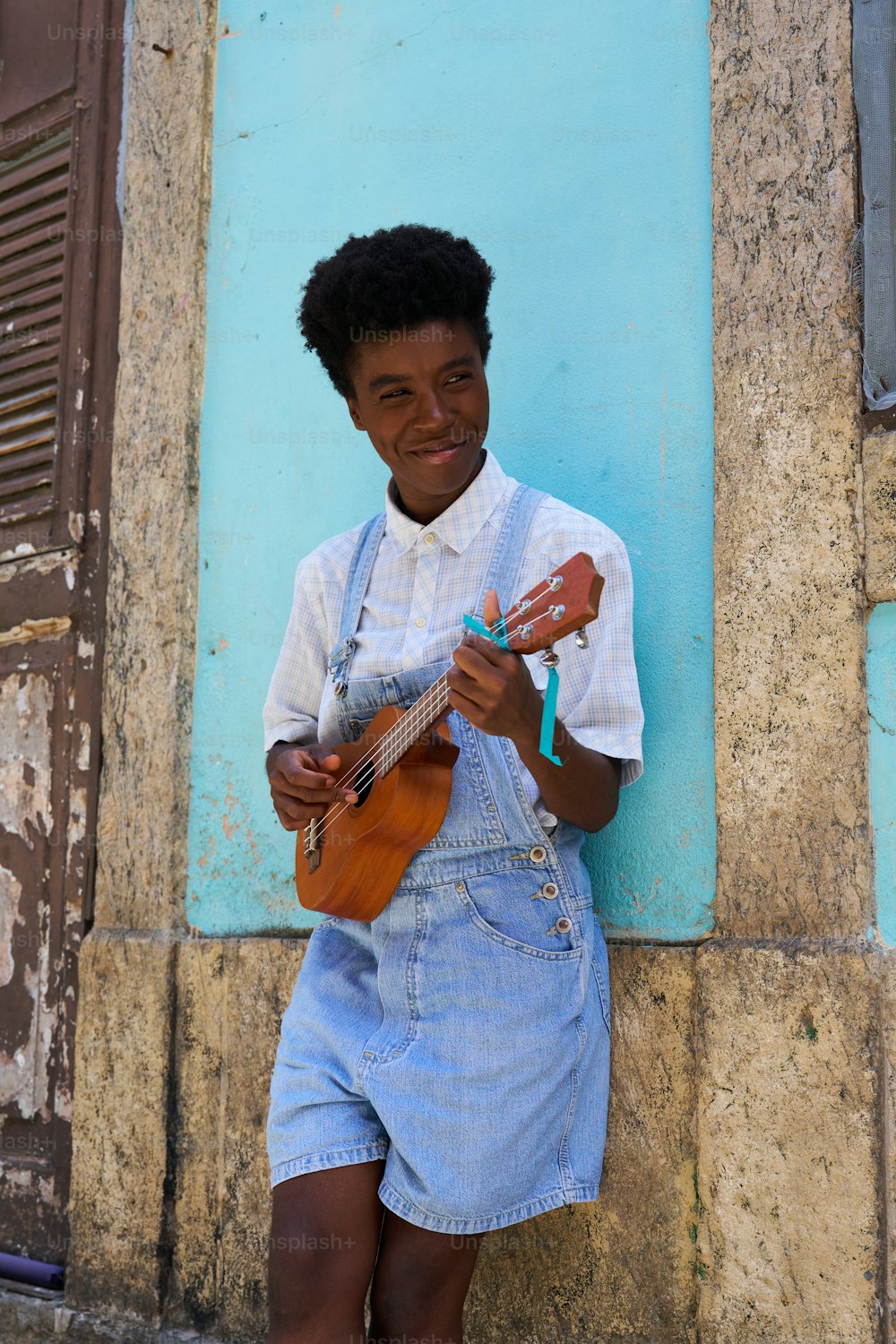 a young man is playing a guitar outside