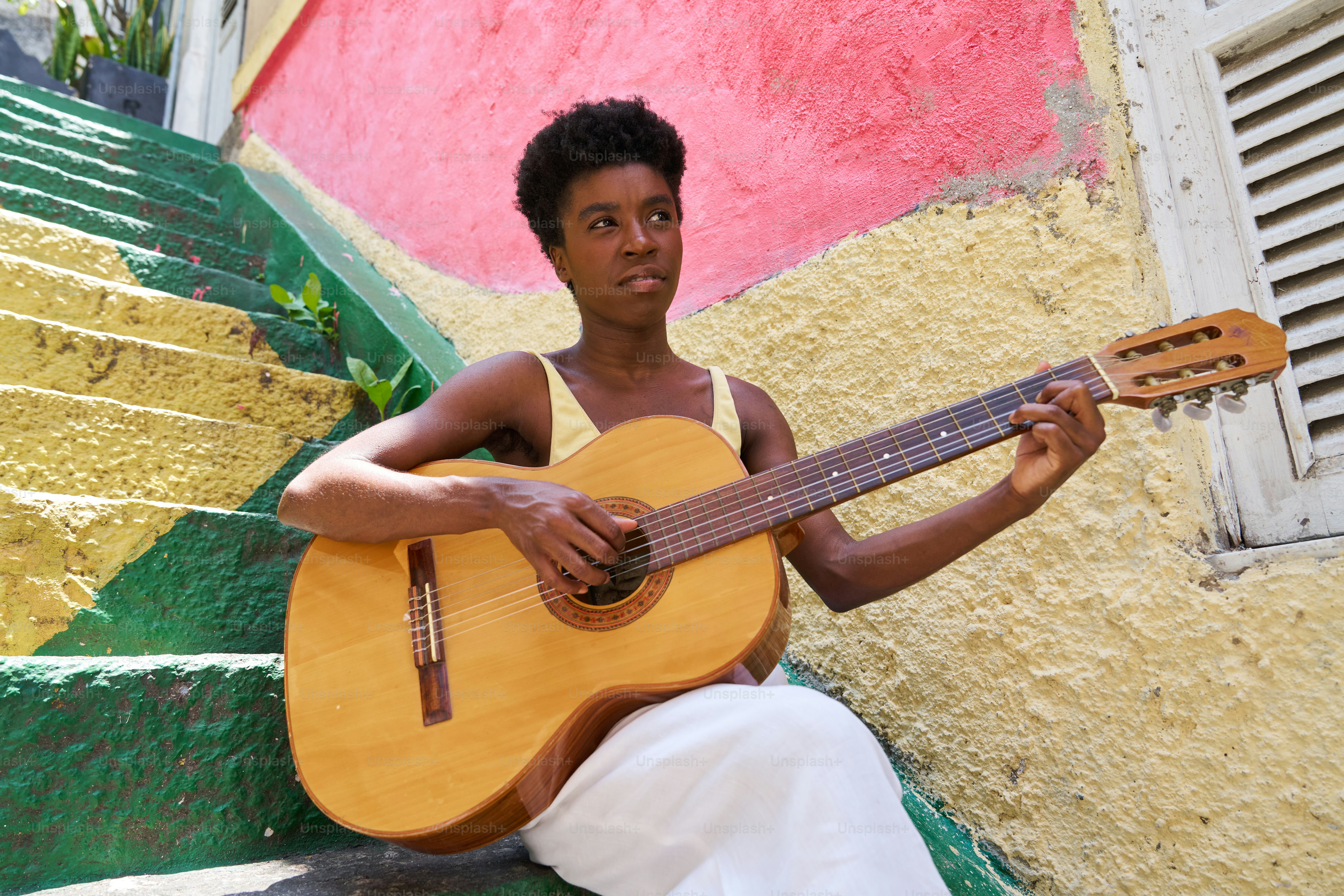 a man sitting on steps holding a guitar