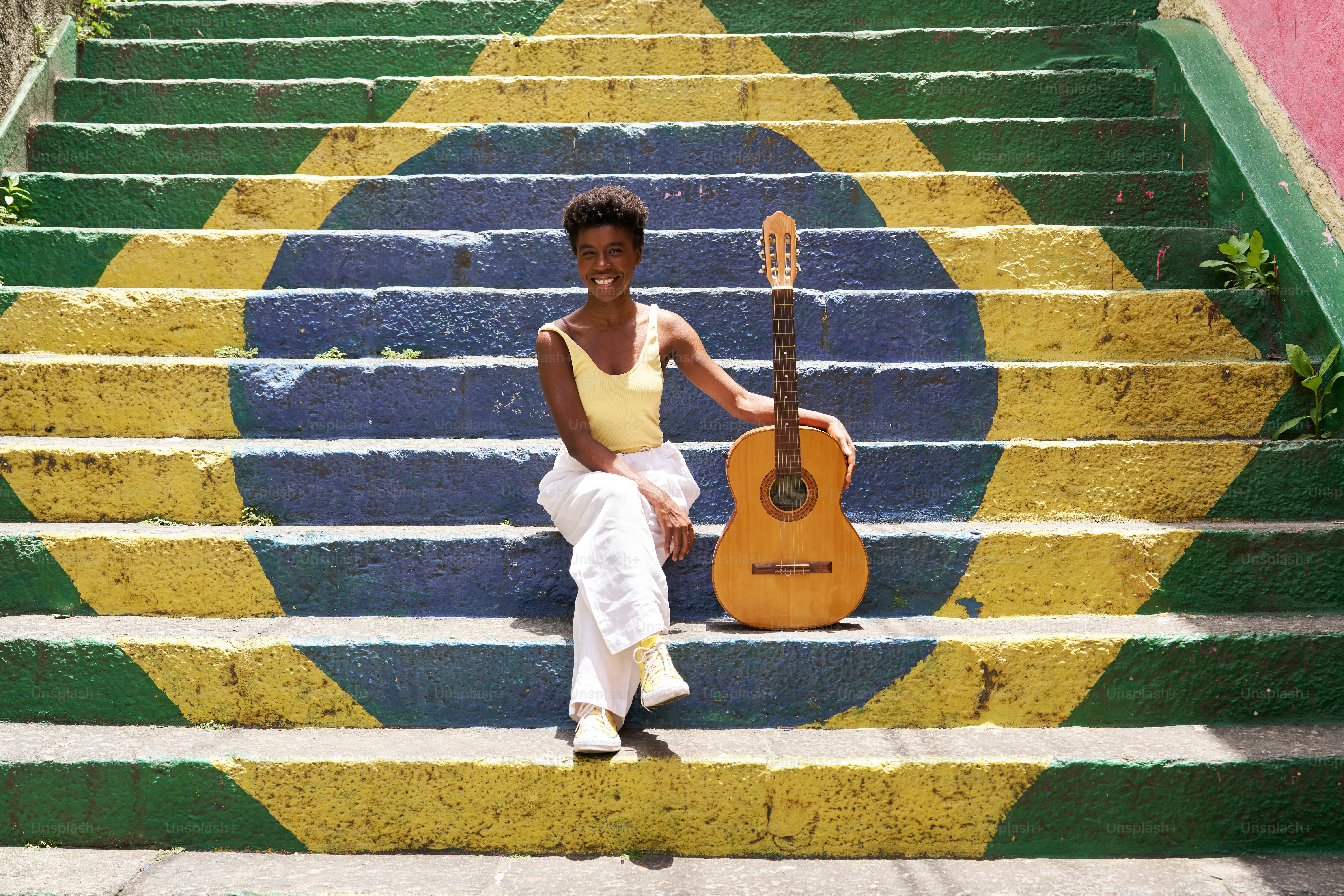 una donna seduta sui gradini con una chitarra