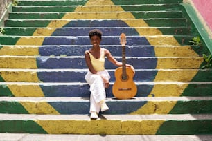 a woman sitting on the steps with a guitar