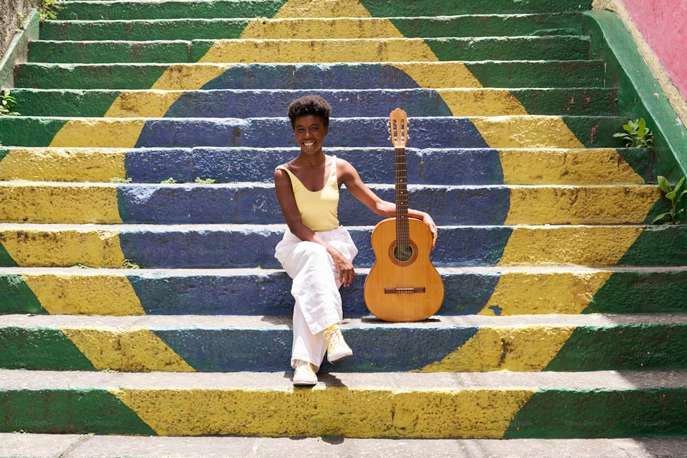 una mujer sentada en los escalones con una guitarra