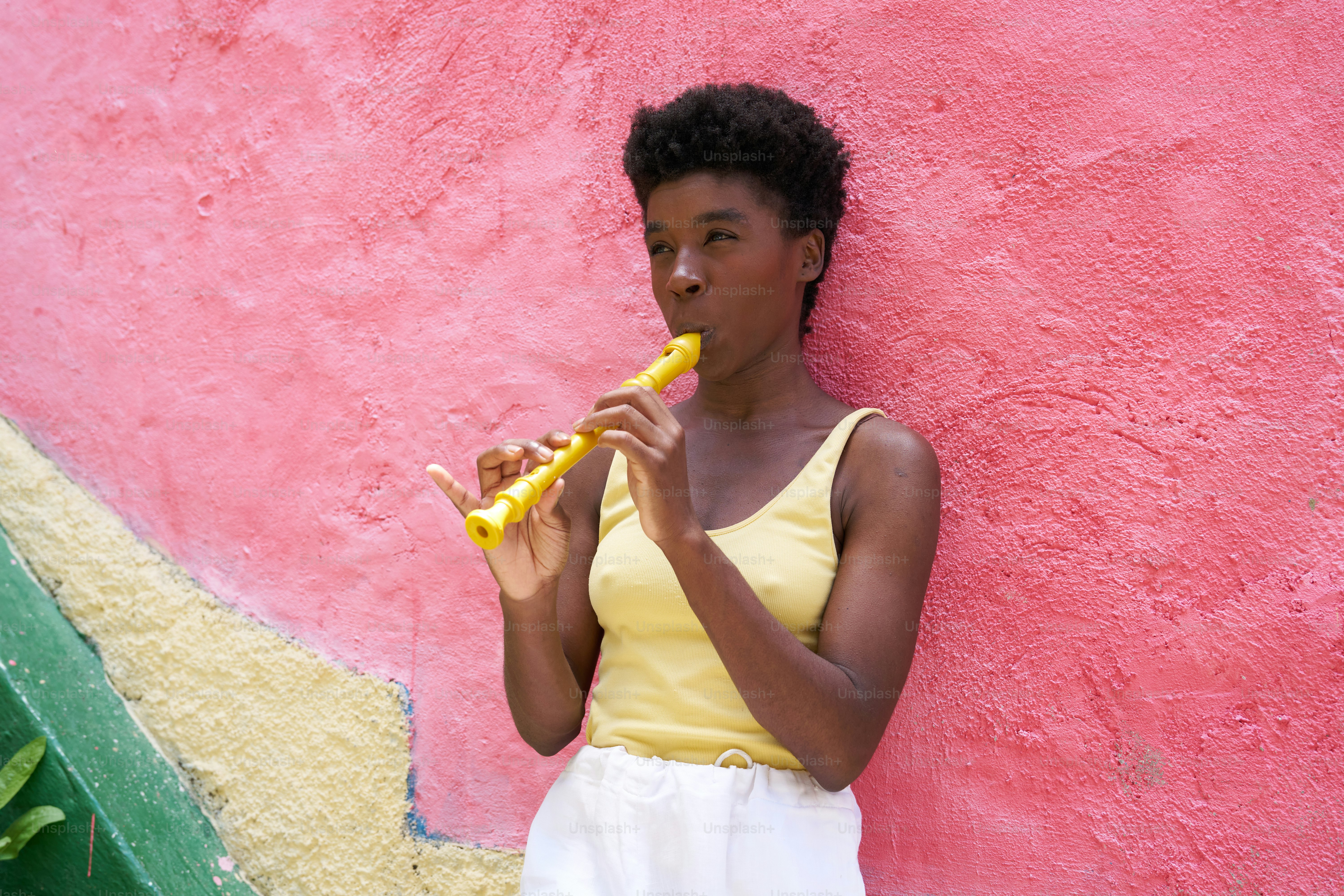 a woman in a yellow top is eating a banana