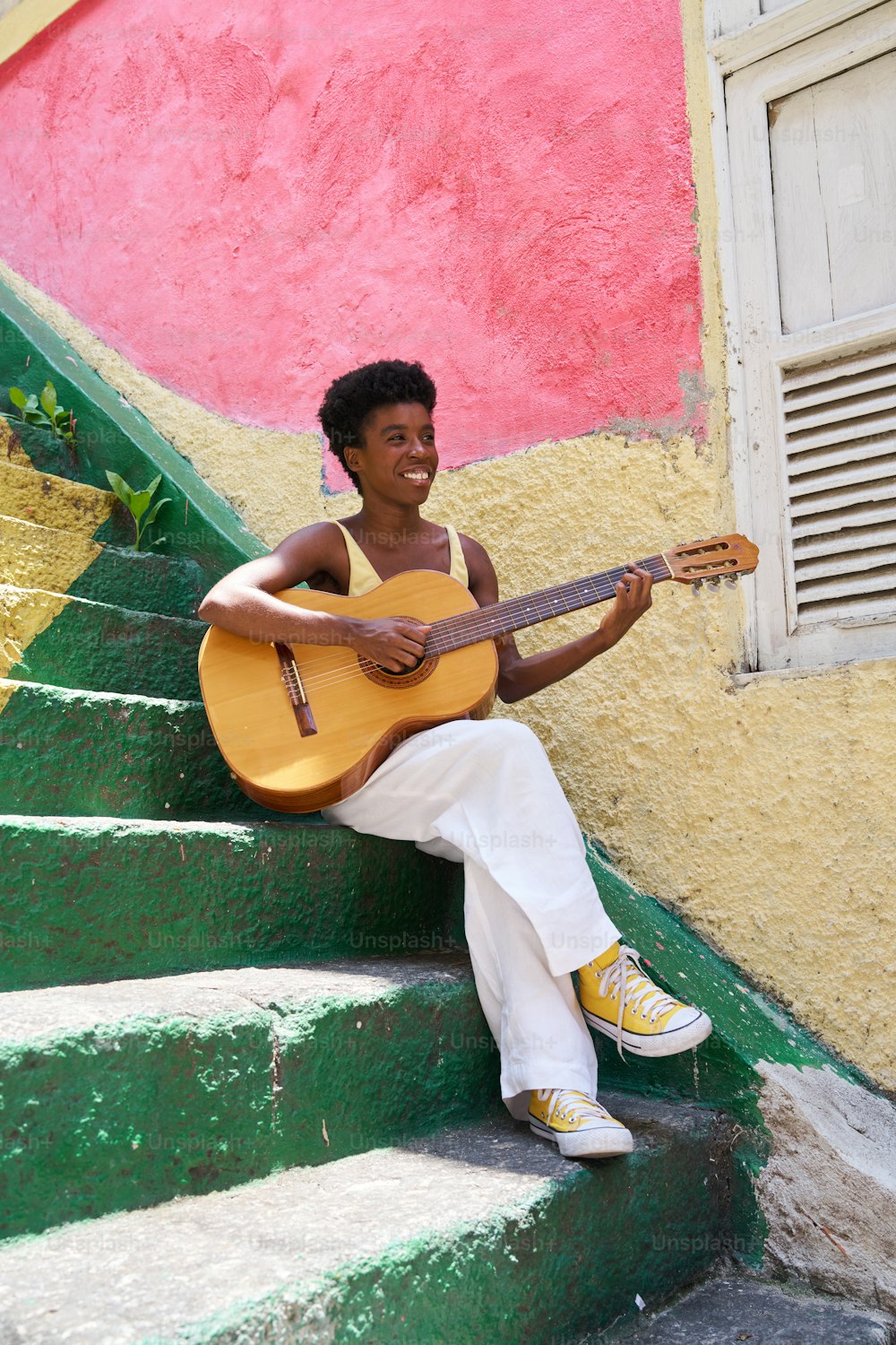 a man sitting on steps playing a guitar