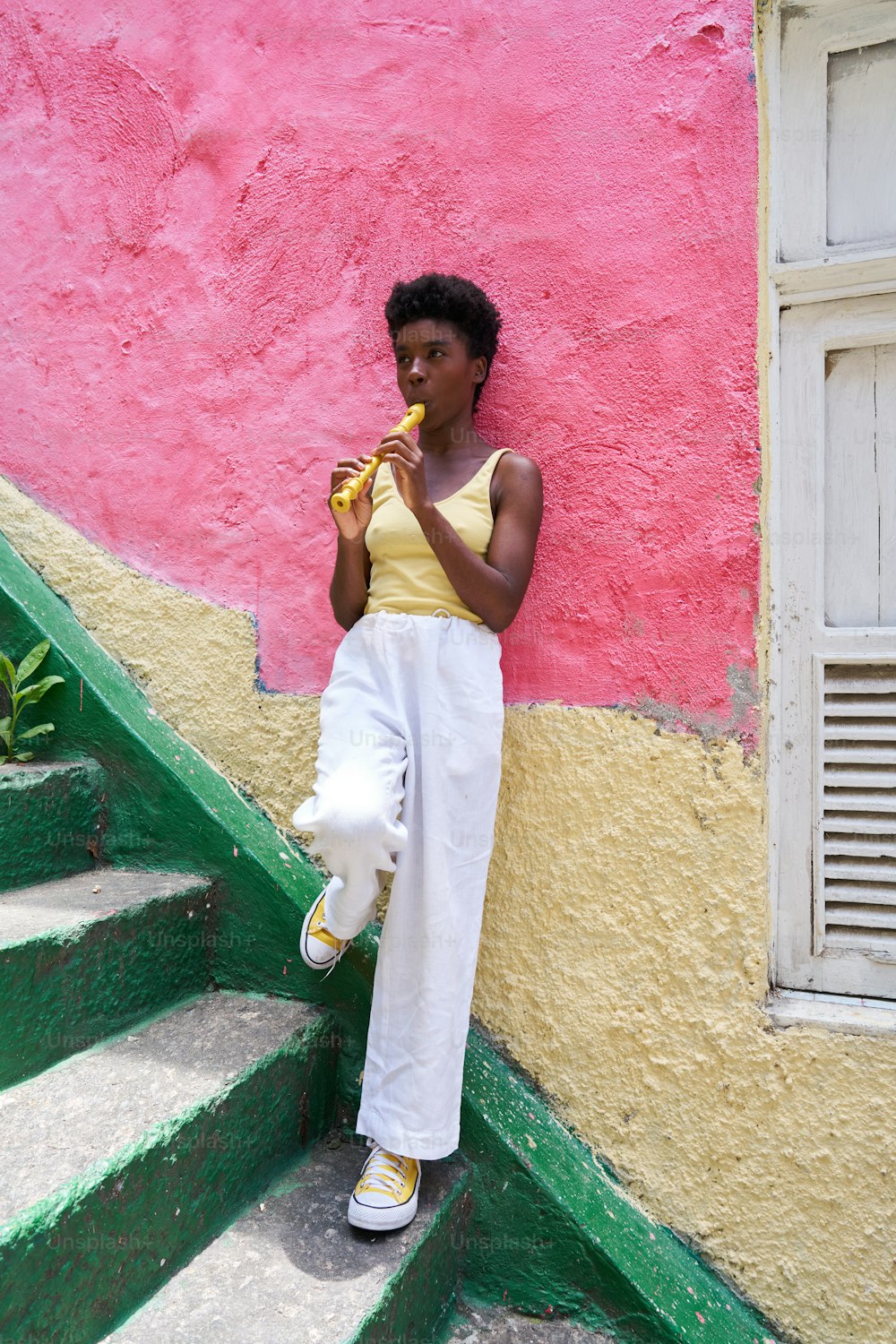 a woman is sitting on the steps eating a banana