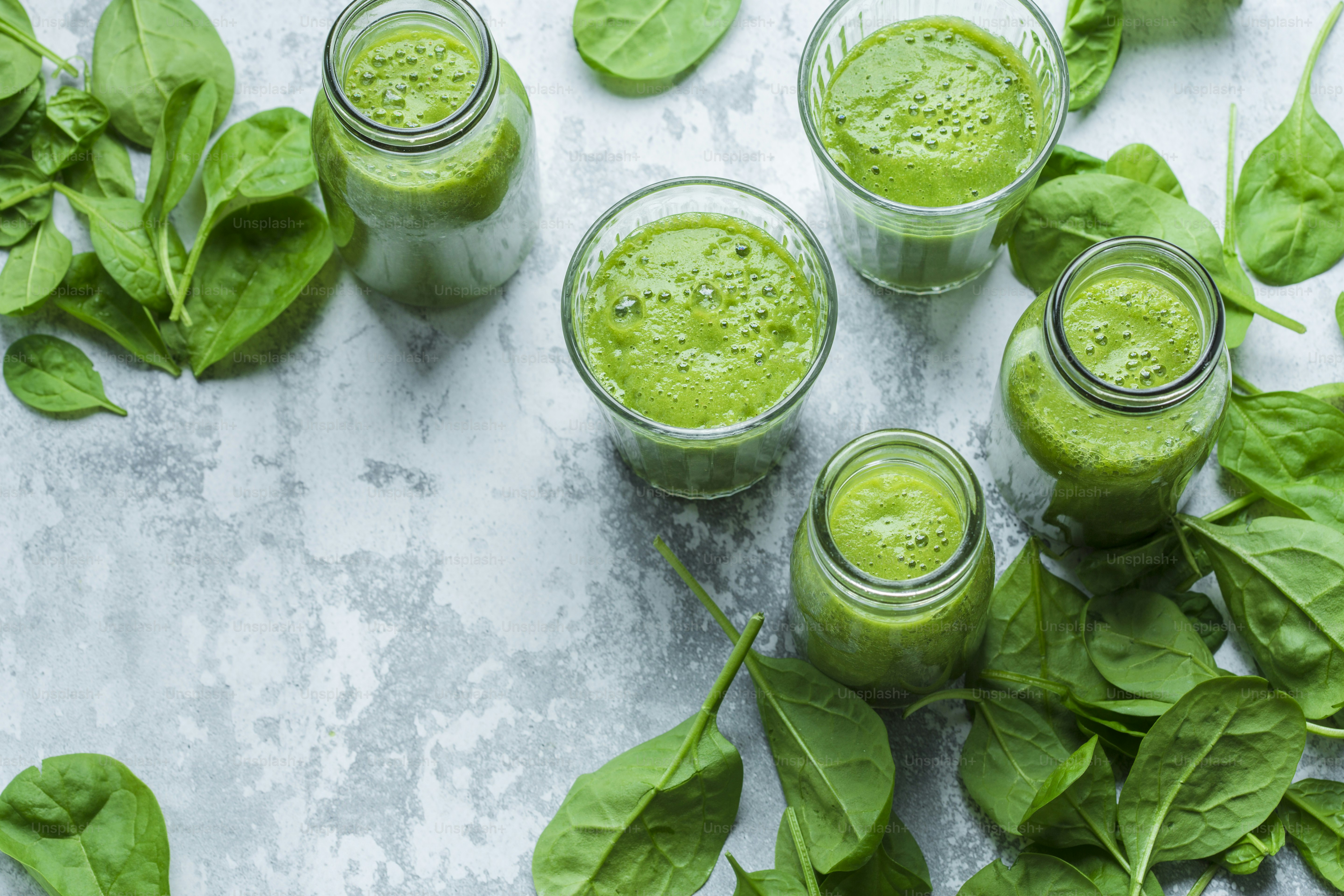 une table surmontée de verres remplis de smoothies verts