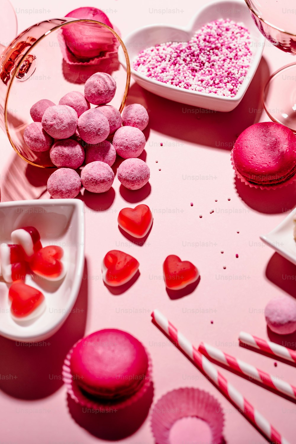 a table topped with lots of pink and red desserts