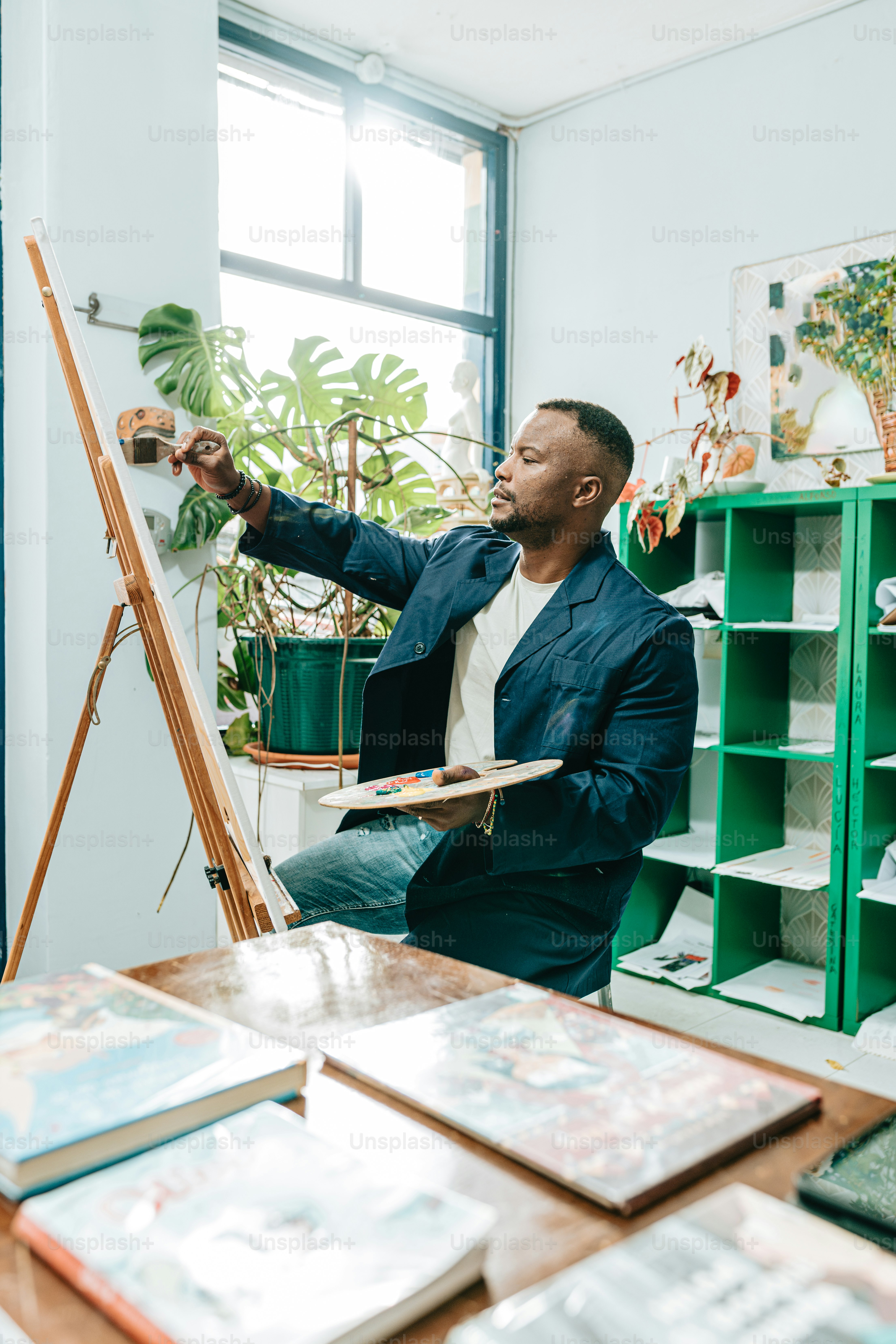 a man sitting on a chair in front of a easel