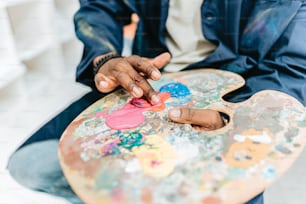 une personne assise sur une chaise avec une palette de peinture